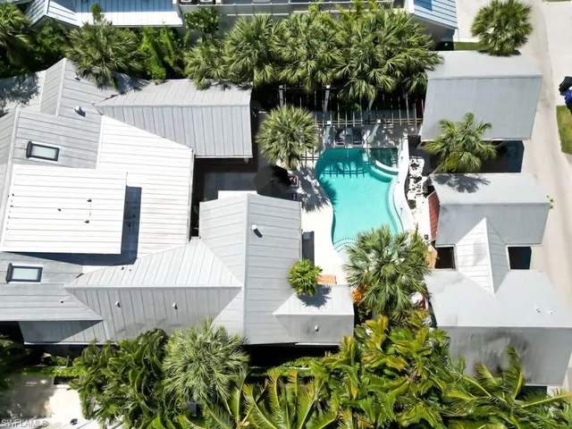 an aerial view of a house with plants and large trees