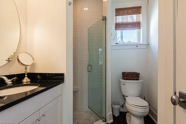 a bathroom with a granite countertop toilet sink and mirror