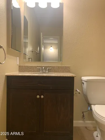 a bathroom with a sink a toilet and mirror