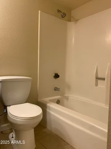 a white toilet sitting next to a bath tub