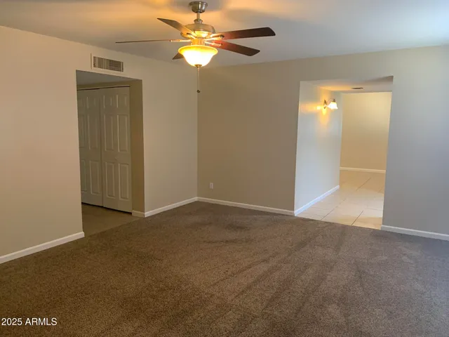 an empty room with closet and a chandelier fan
