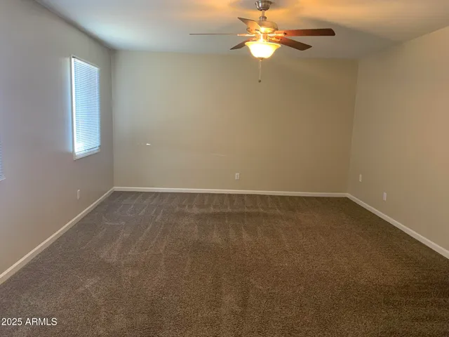 an empty room with a window and a fan