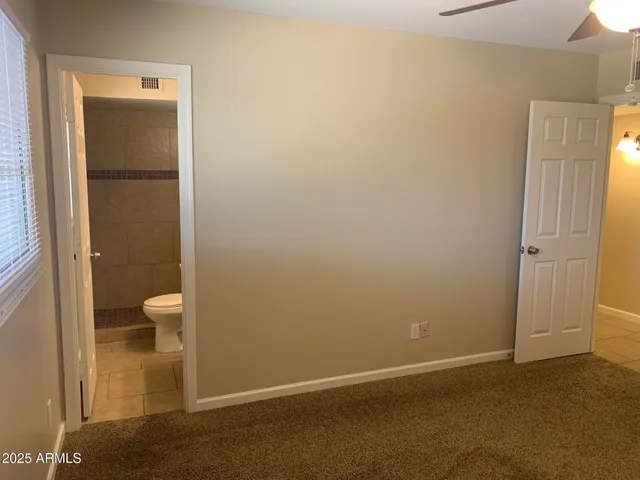 an empty room and a bathroom with toilet