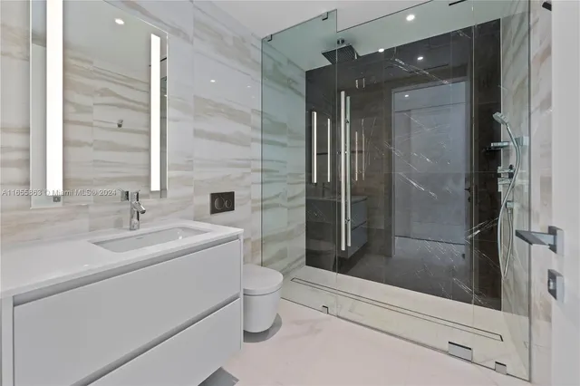 a bathroom with a shower a sink and toilet