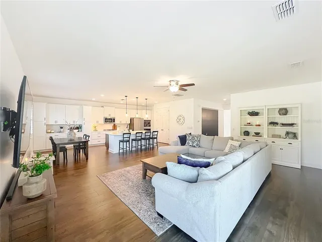 a living room with furniture and view of kitchen