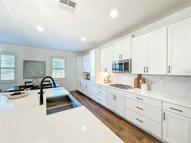 a kitchen with granite countertop a sink a stove and cabinets
