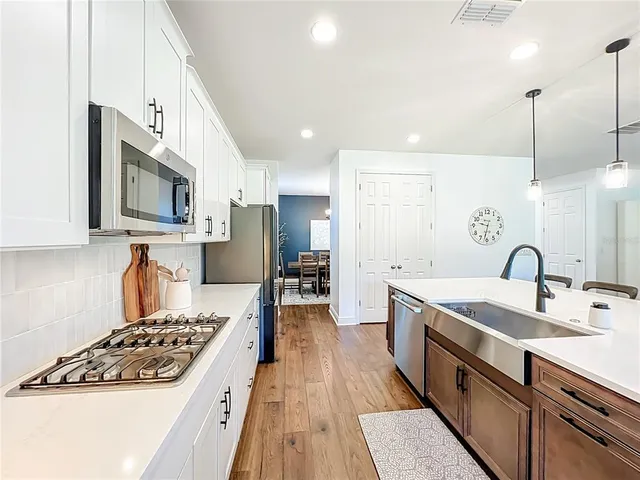 a large kitchen with stainless steel appliances granite countertop a lot of counter space and wooden floors