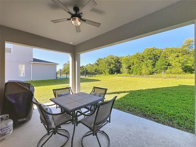a view of a chairs and table in patio with a yard
