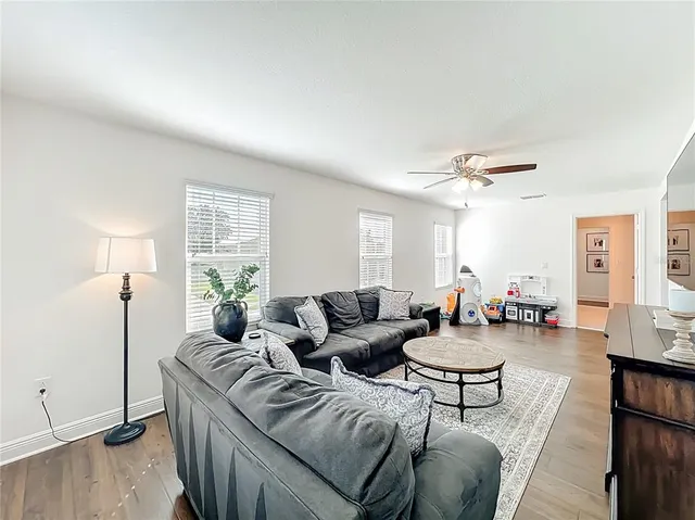 a living room with furniture and a ceiling fan