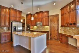 9265 East Canyon View Road Scottsdale, AZ 85255 - Photo 8 of 39 a kitchen with kitchen island granite countertop a sink a counter top space stainless steel appliances and cabinets