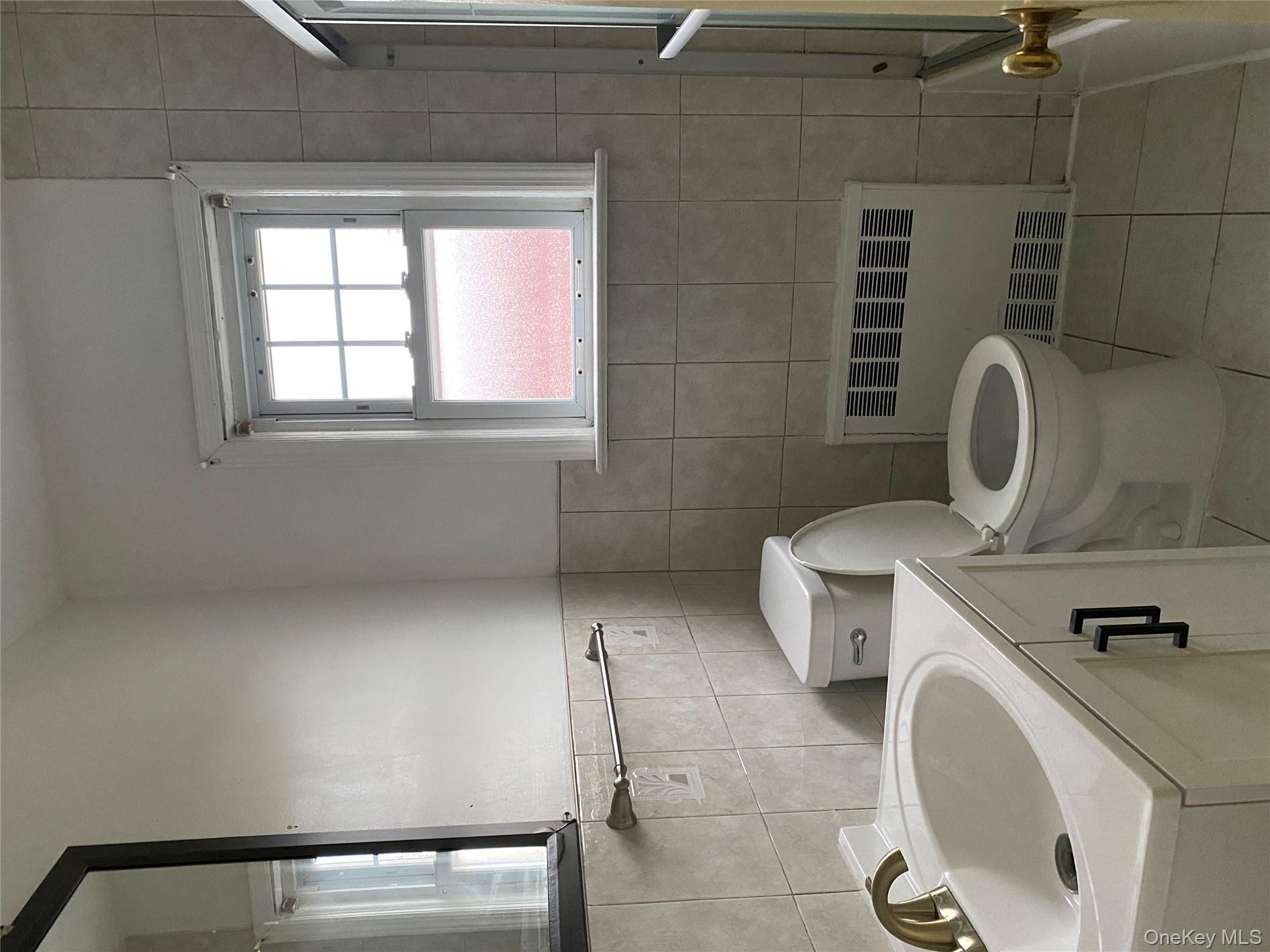 192 Beech Street Valley Stream, NY 11580 - Photo 3 of 5 a bathroom with a toilet a sink and a window