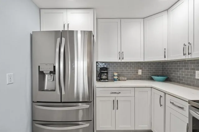 a kitchen with a sink dishwasher a stove and white cabinets with wooden floor