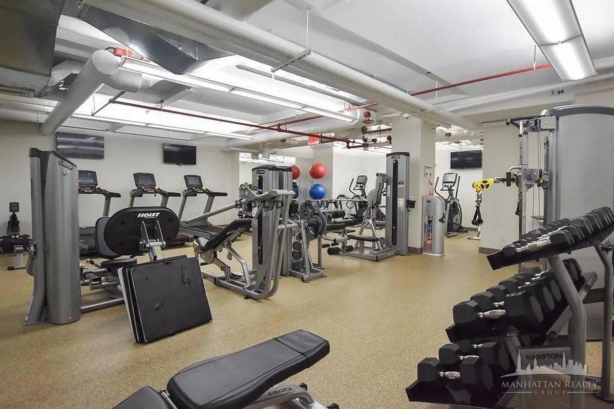 95 Christopher Street, Unit 4J Manhattan, NY 10014 - Photo 5 of 8 a room with gym equipment and a large window