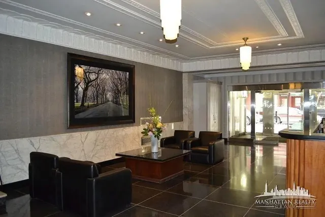a living room with large couches bookshelf and a chandelier