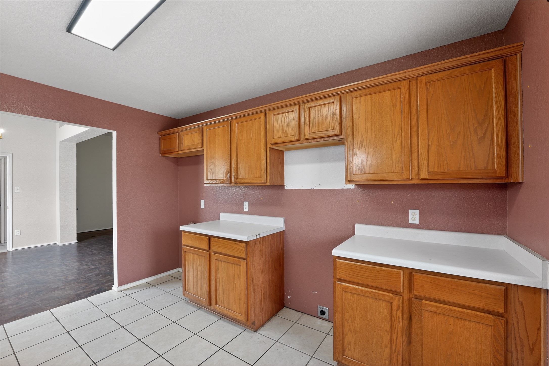 152 Eagle Drive Luling, TX 78648 - Photo 11 of 31 Kitchen featuring wood finish cabinetry, light countertops, and light tile patterned flooring