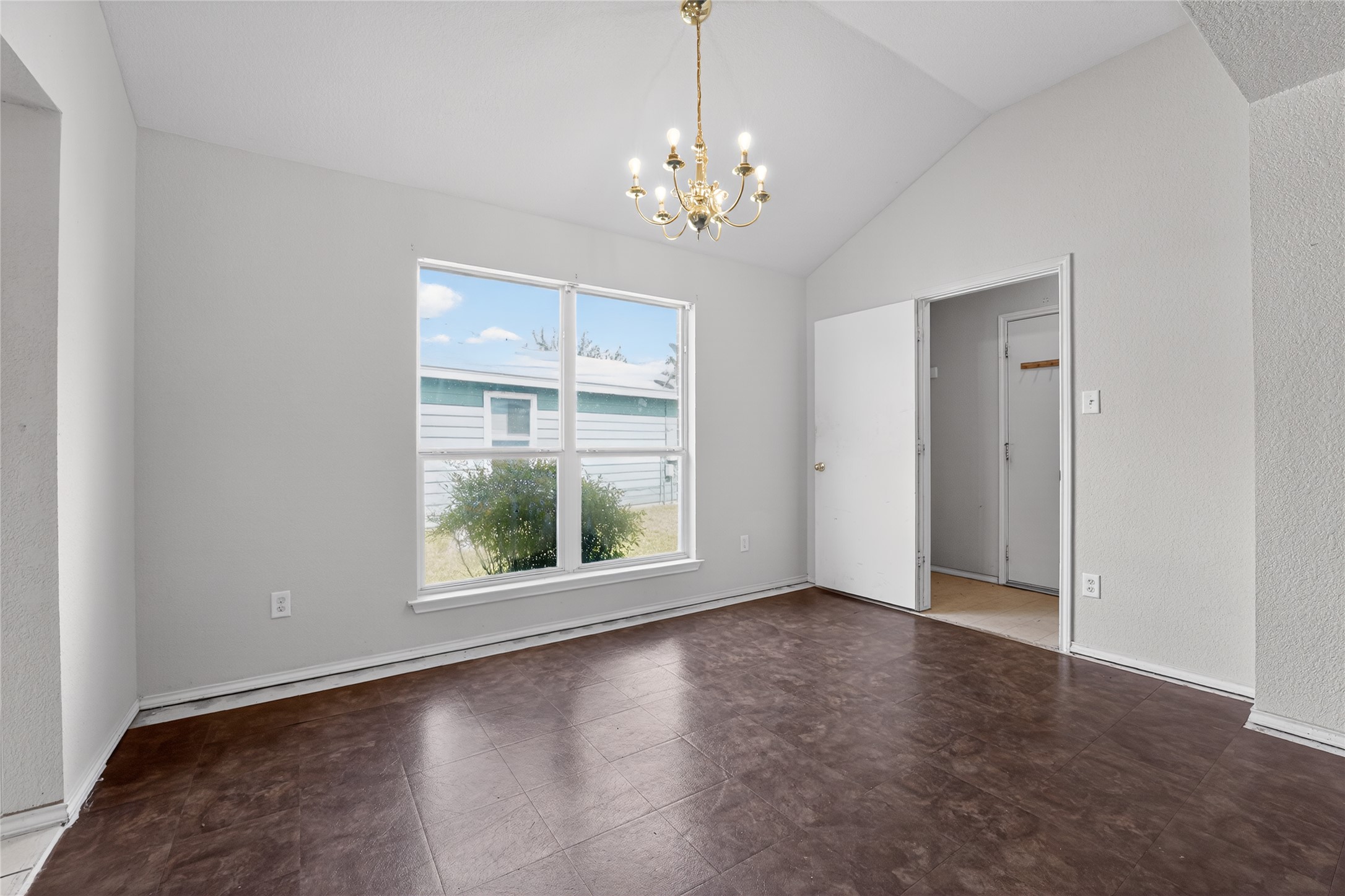152 Eagle Drive Luling, TX 78648 - Photo 14 of 31 Unfurnished dining area with hanging lights, a textured wall, and vaulted ceiling