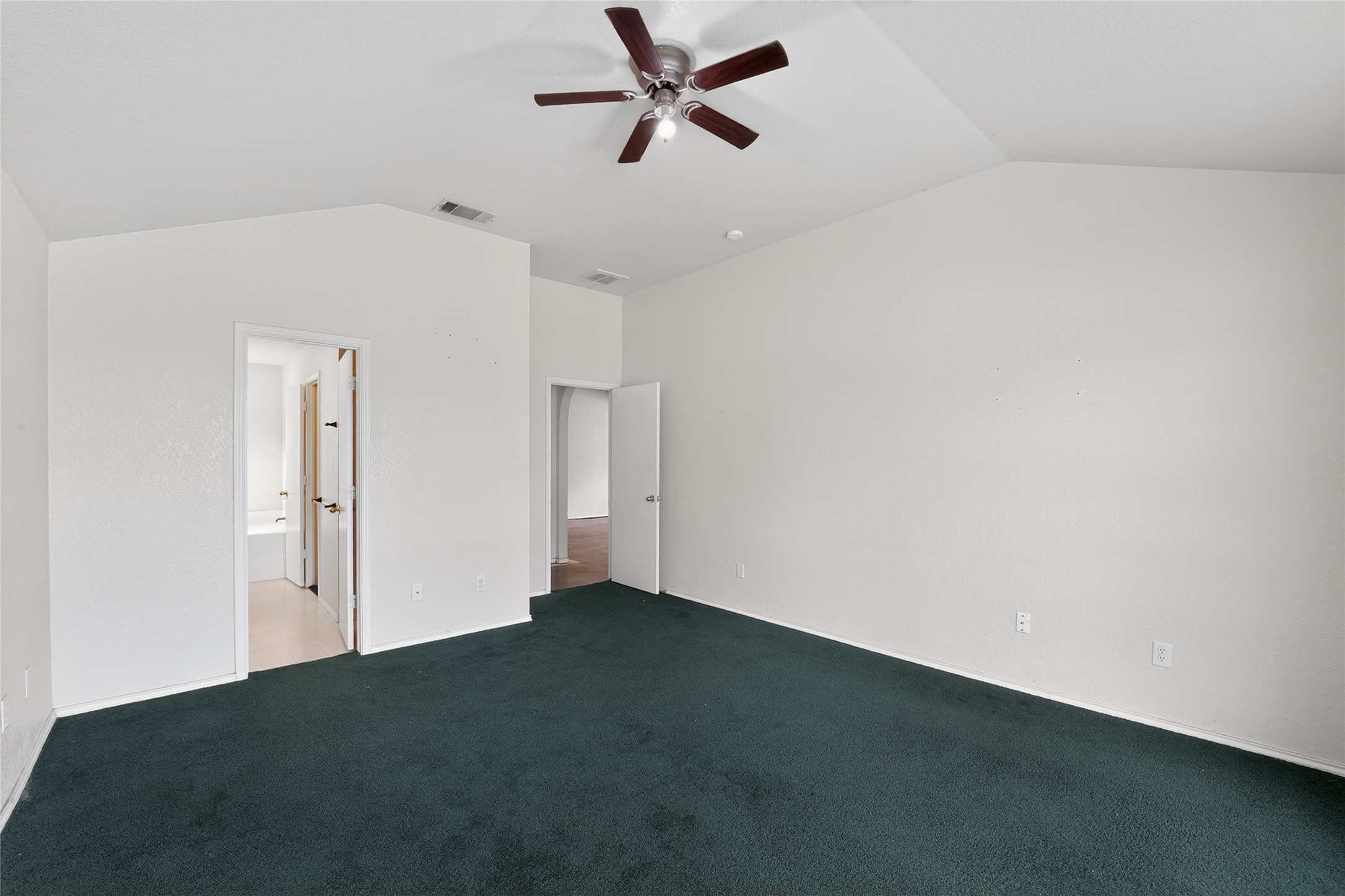 152 Eagle Drive Luling, TX 78648 - Photo 27 of 31 Unfurnished bedroom with ceiling fan, dark colored carpet, and ensuite bath