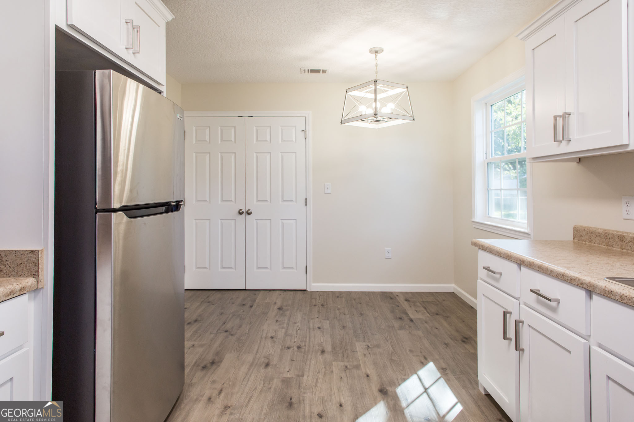 121 Union Street Waycross, GA 31501 - Photo 11 of 25 an empty room with wooden floor cabinet and windows