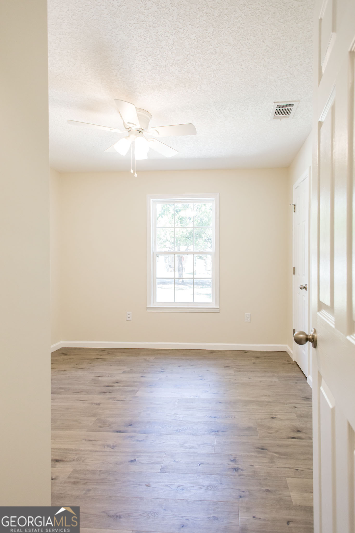 121 Union Street Waycross, GA 31501 - Photo 13 of 25 an empty room with wooden floor and windows