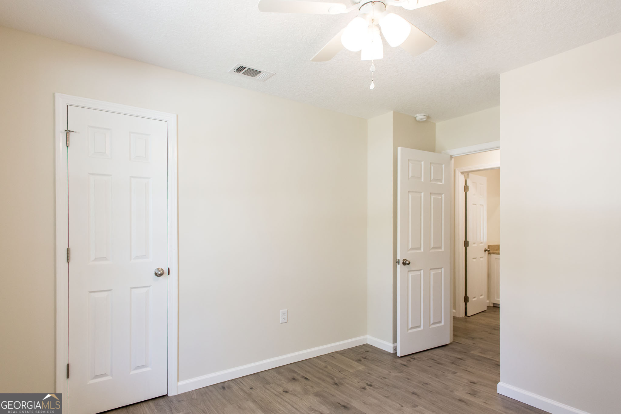 121 Union Street Waycross, GA 31501 - Photo 14 of 25 an empty room with wooden floor and a ceiling fan