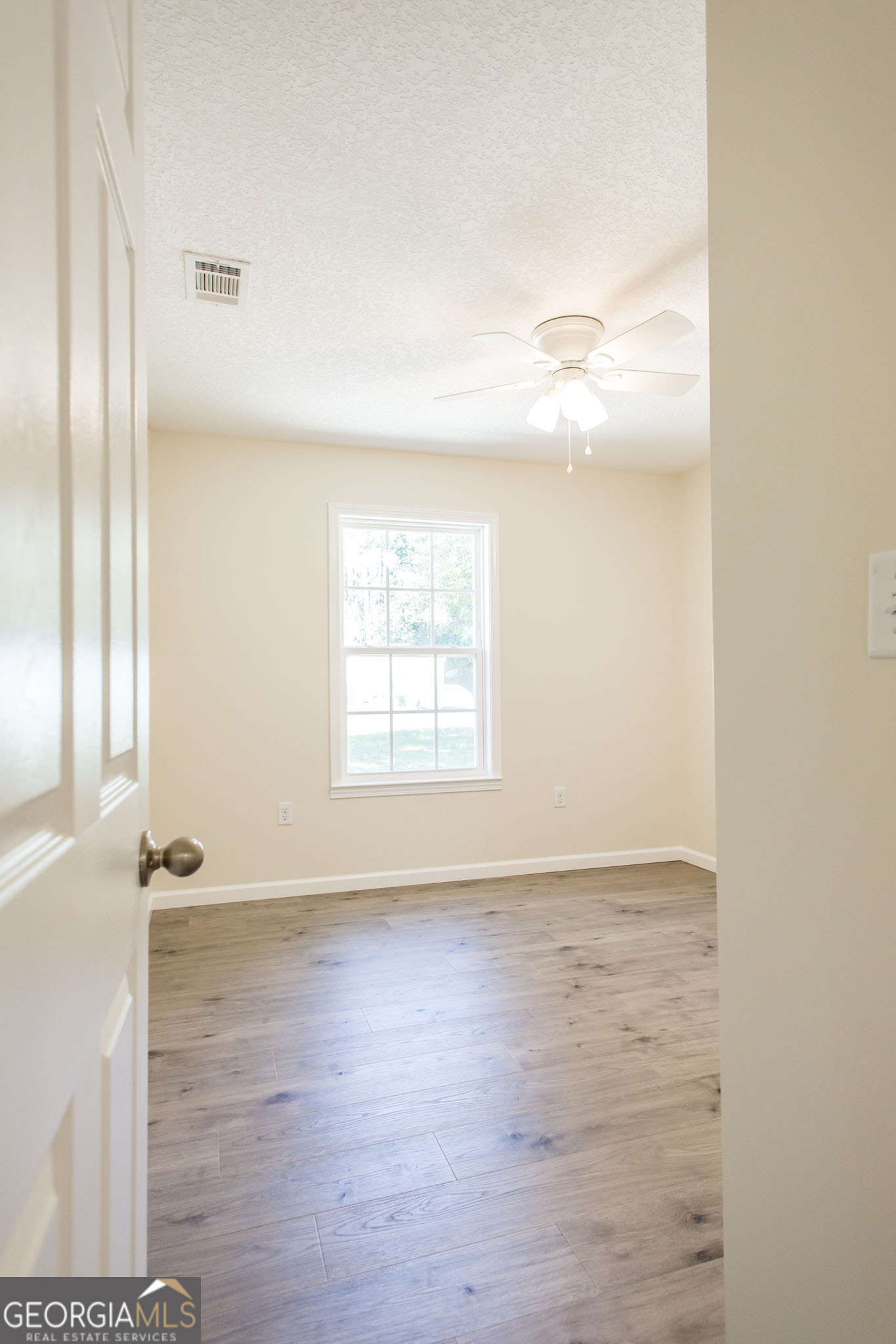 121 Union Street Waycross, GA 31501 - Photo 17 of 25 an empty room with wooden floor and windows