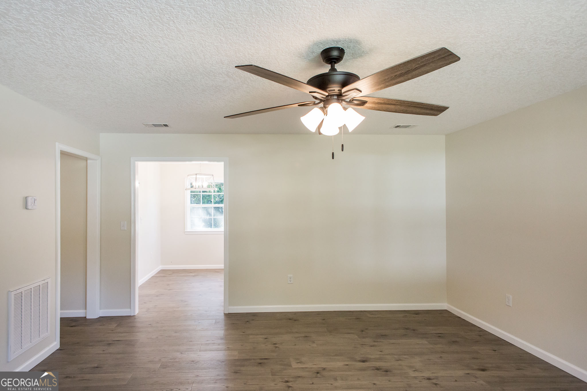 121 Union Street Waycross, GA 31501 - Photo 5 of 25 wooden floor in an empty room with a window