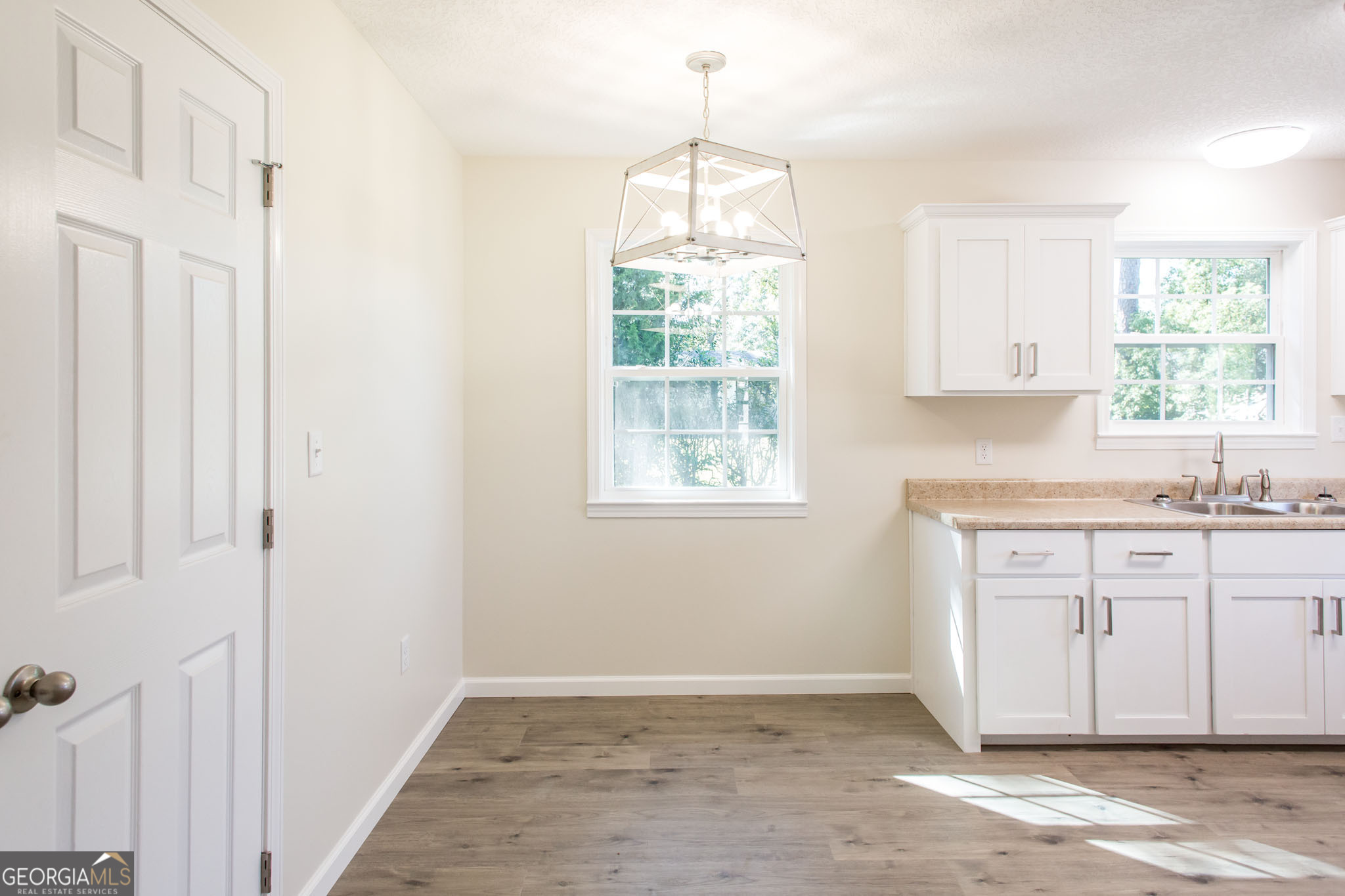121 Union Street Waycross, GA 31501 - Photo 6 of 25 a kitchen with granite countertop white cabinets window and a sink