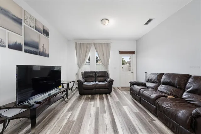 a living room with furniture and a wooden floor