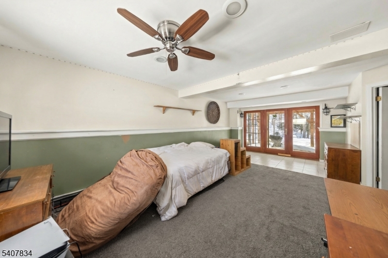 31 Meadow Lane Vernon, NJ 07462 - Photo 26 of 43 a bed room with a bed and a chandelier