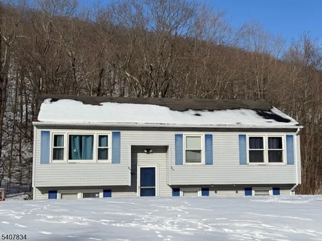 a view of a white house with a big yard and large trees