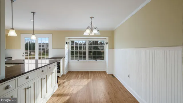 a view of a kitchen with wooden floor and windows