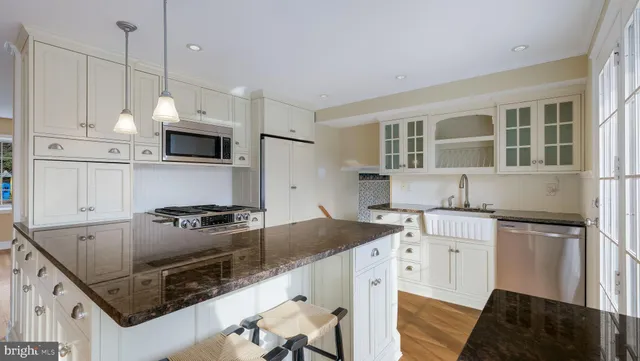 a kitchen with stainless steel appliances granite countertop a sink a microwave a stove and a microwave