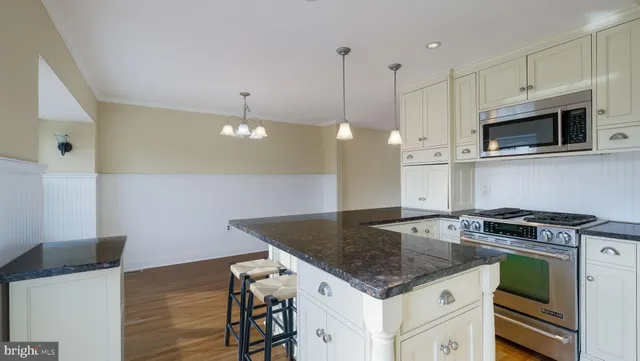 a kitchen with a refrigerator a sink and wooden floor