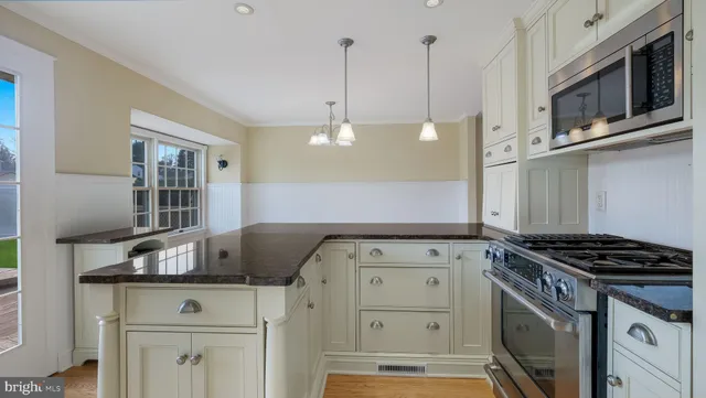 a kitchen with stainless steel appliances granite countertop a sink stove and cabinets