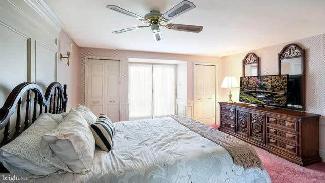 a bedroom with a bed a chandelier and a window