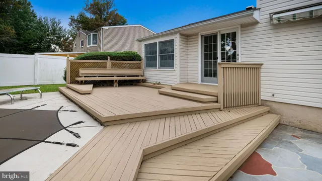a view of a house with a barbeque and wooden stairs