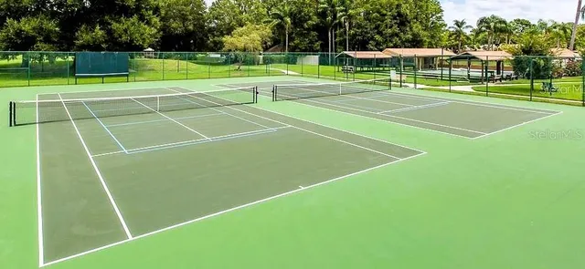a green field with lots of trees in the background