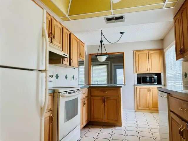a kitchen with stainless steel appliances granite countertop a refrigerator and a stove top oven