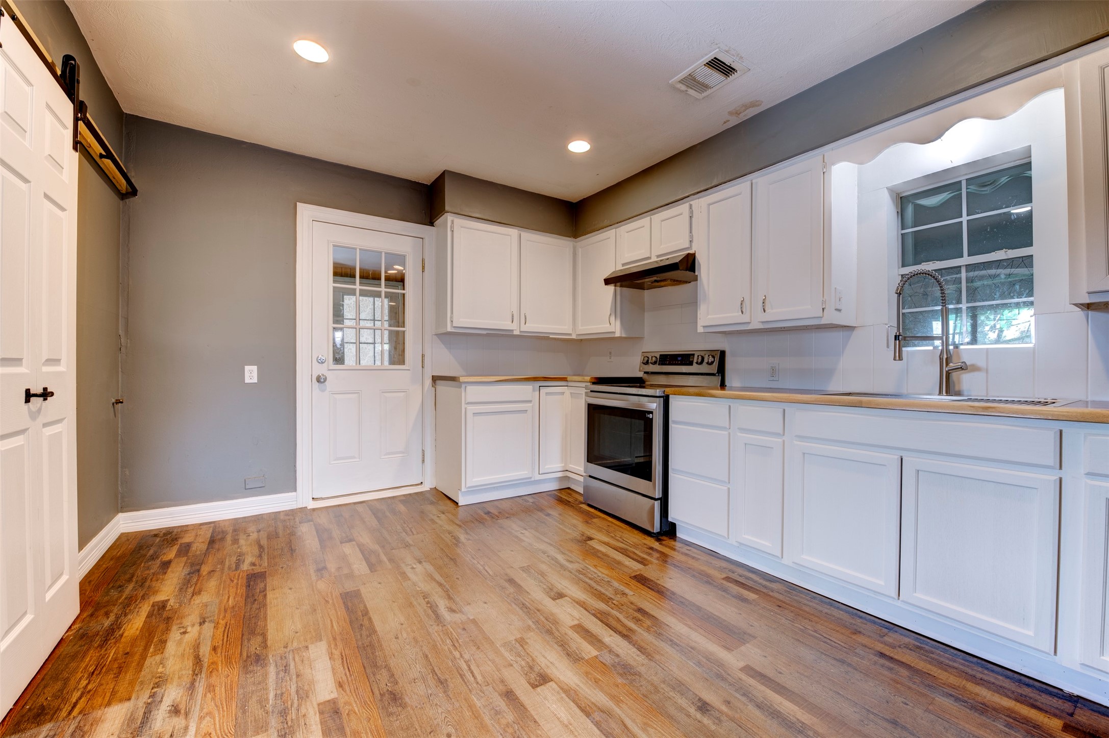 4303 Castor Street Houston, TX 77022 - Photo 12 of 41 a kitchen with granite countertop a sink cabinets stainless steel appliances and a window
