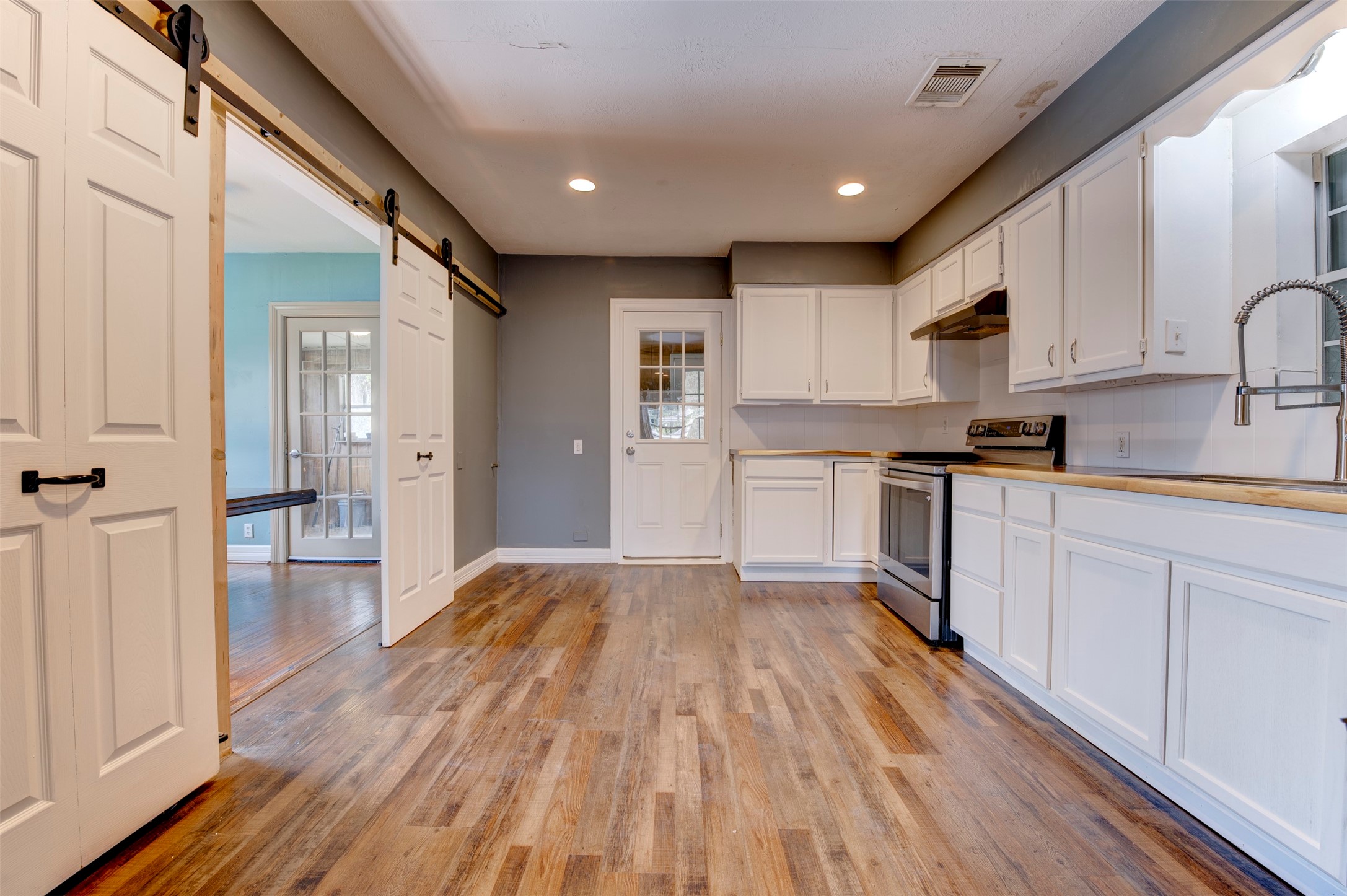 4303 Castor Street Houston, TX 77022 - Photo 13 of 41 a large kitchen with a wooden floor and stainless steel appliances