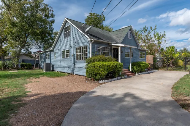 a view of a house next to a yard with big trees