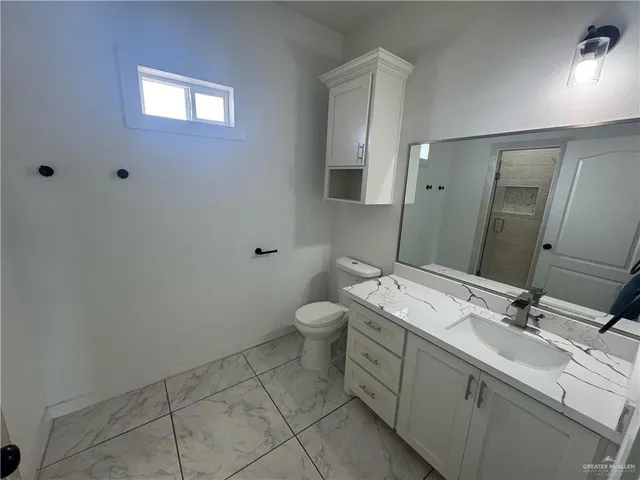 a spacious bathroom with a double vanity sink toilet and a mirror