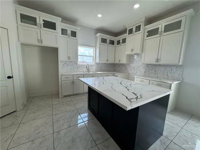a kitchen with a sink window and cabinets