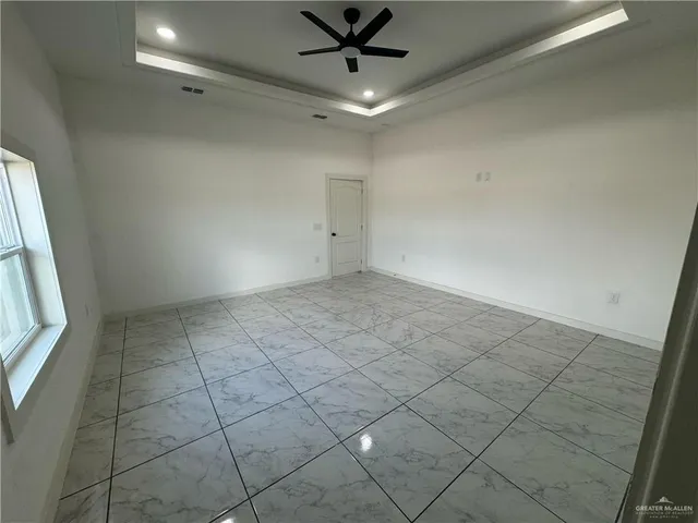 an empty room with a ceiling fan and window