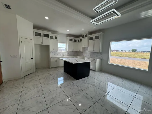 a large kitchen with stainless steel appliances granite countertop a refrigerator and a stove top oven