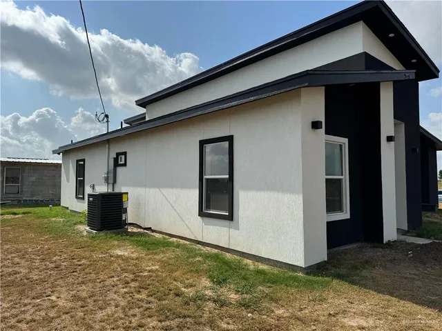 a backyard of a house with barbeque oven table and chairs