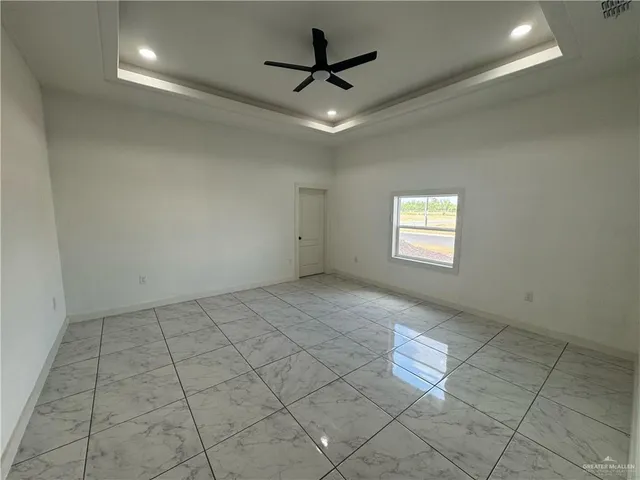 a view of an empty room and a ceiling fan window