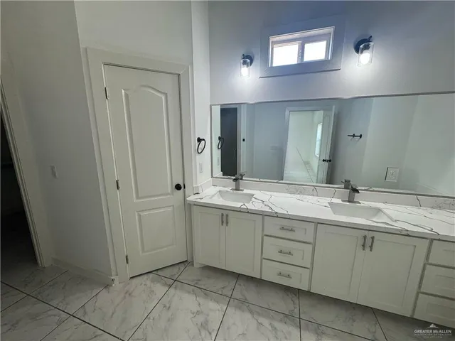 a bathroom with a granite countertop sink and a mirror