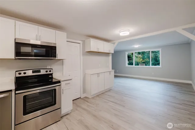 a kitchen with a sink a microwave and cabinets