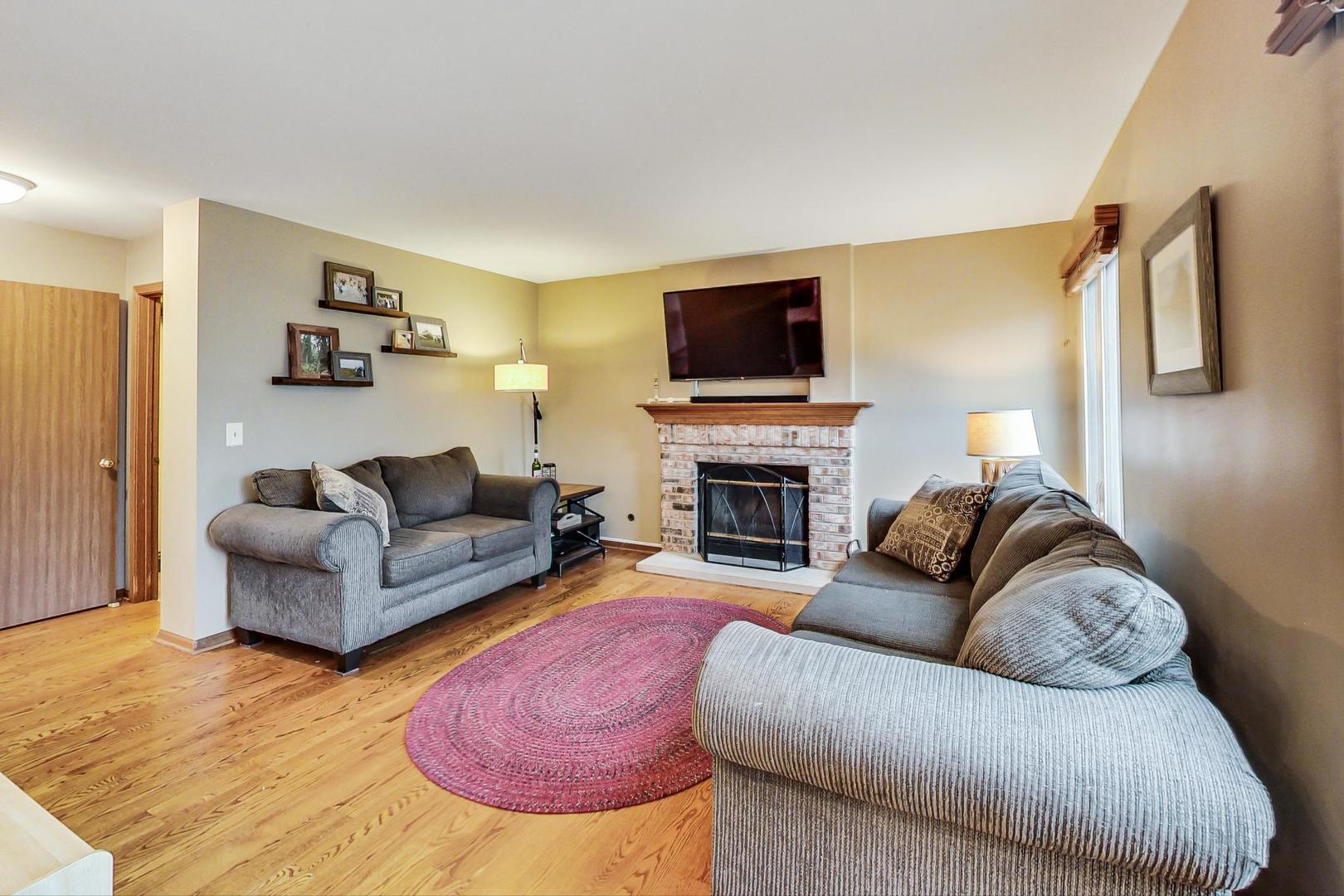 1174 Sweetwater Ridge Lake In The Hills, IL 60156 - Photo 12 of 44 a living room with furniture a flat screen tv and a fireplace